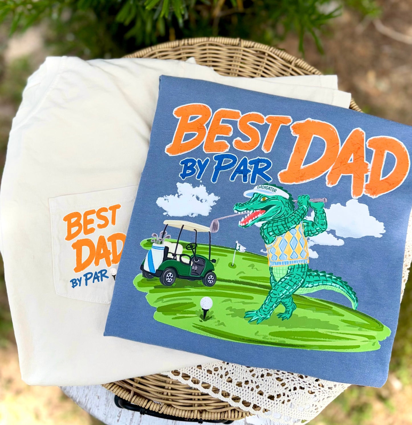Best Dad By Par golf shirt featuring a front pocket design and full back graphic with a fun golf-playing alligator character on the golf course. ⛳🐊