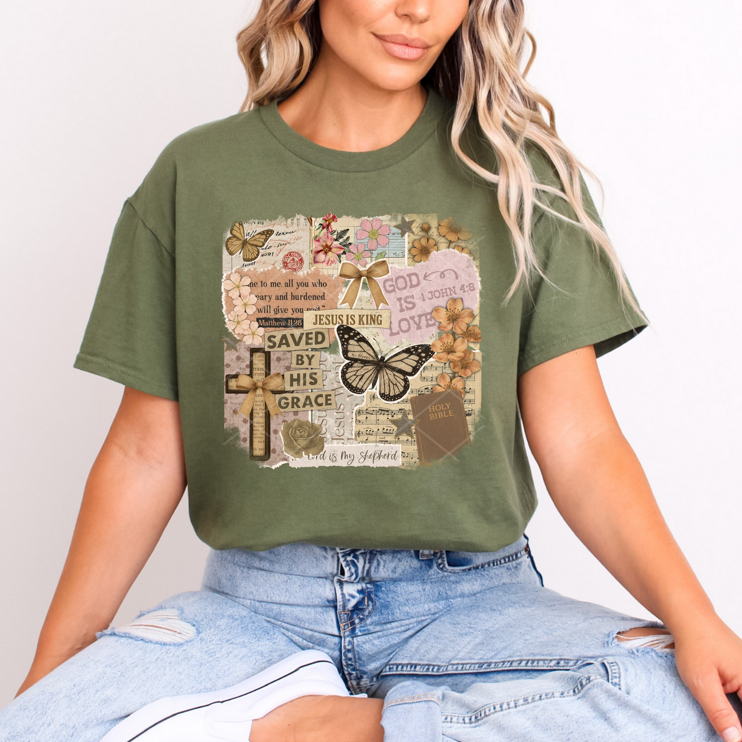 Christian scrapbook collage graphic tee on sage green shirt with butterflies, florals, Bible quotes, and faith-themed elements.