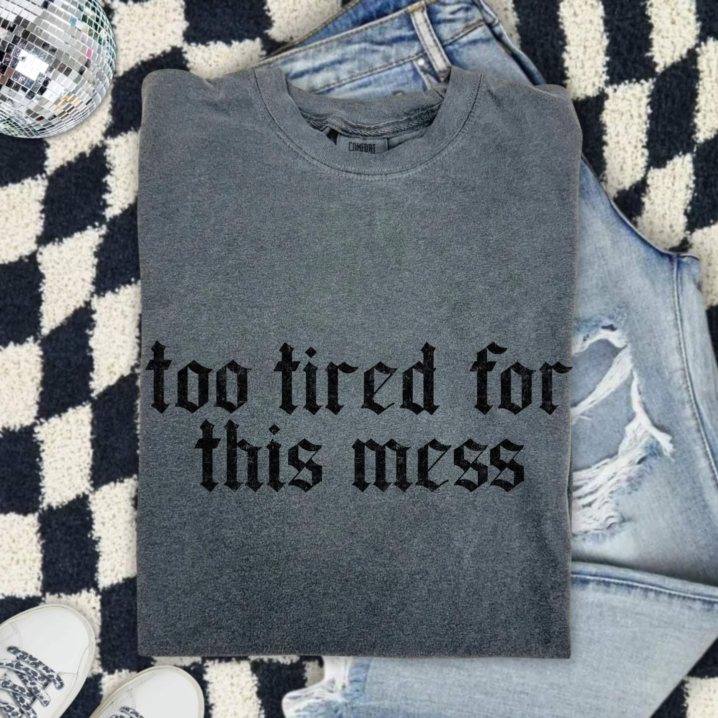 Too Tired for This Mess graphic tee in gothic black font on heather grey shirt, flat lay with jeans
