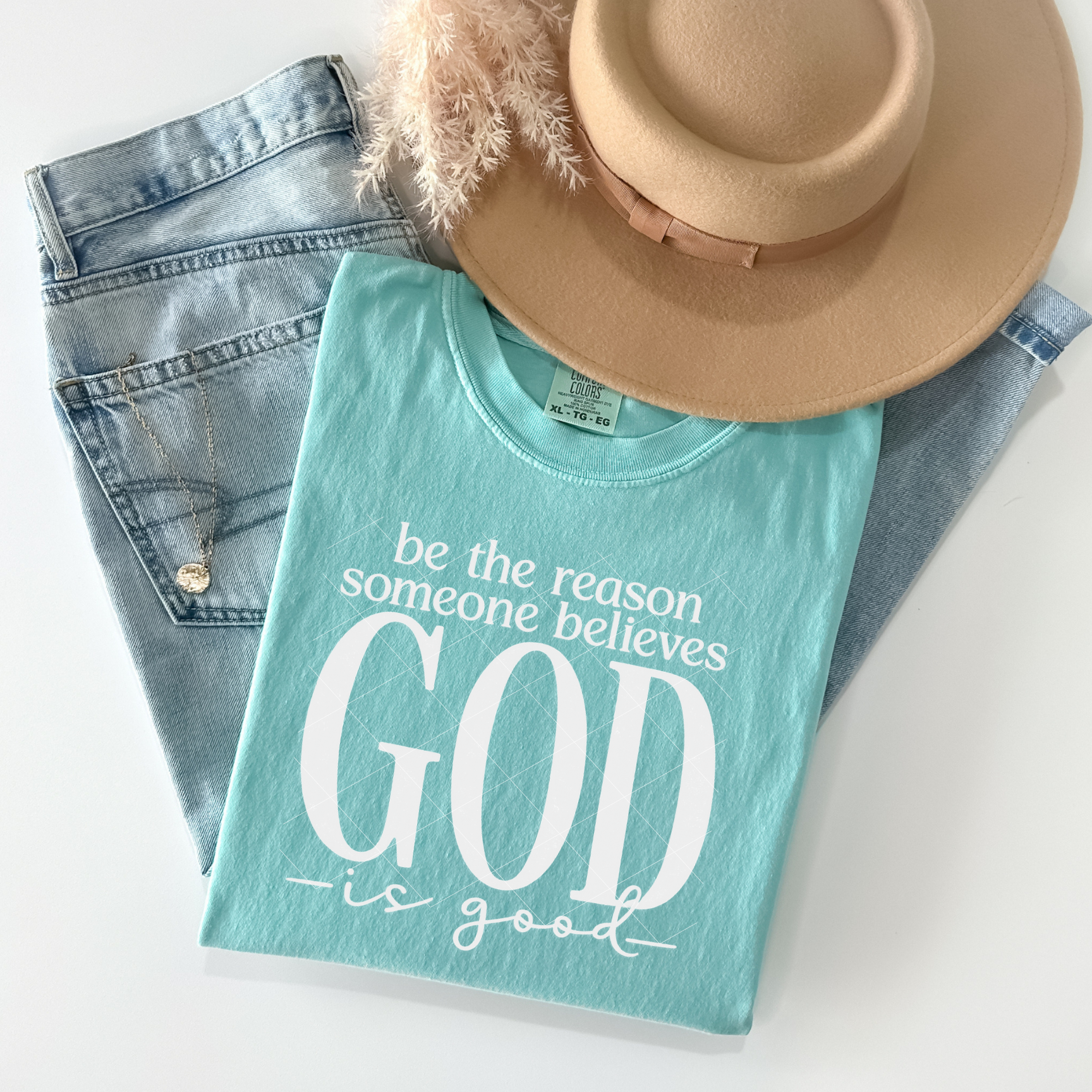 Mint Comfort Colors Christian t-shirt folded flat with the quote ‘Be the reason someone believes God is good’ displayed in white text.