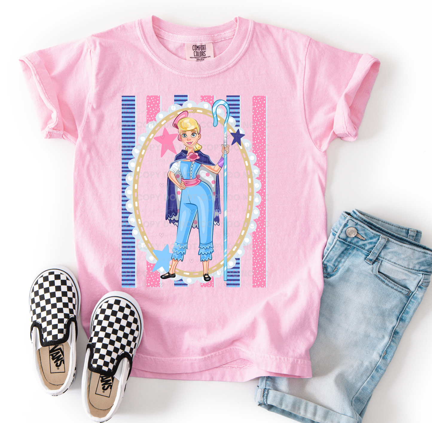 Bo Peep-inspired character design printed on a Comfort Colors t-shirt featuring pastel pink and blue colors, stars, stripes, and shepherd-inspired details, perfect for Disney vacations and Toy Story fans.