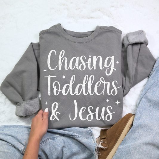 Chasing Toddlers & Jesus sweatshirt in Comfort Colors Gray — soft unisex crewneck displayed with rolled sleeves and denim jeans.