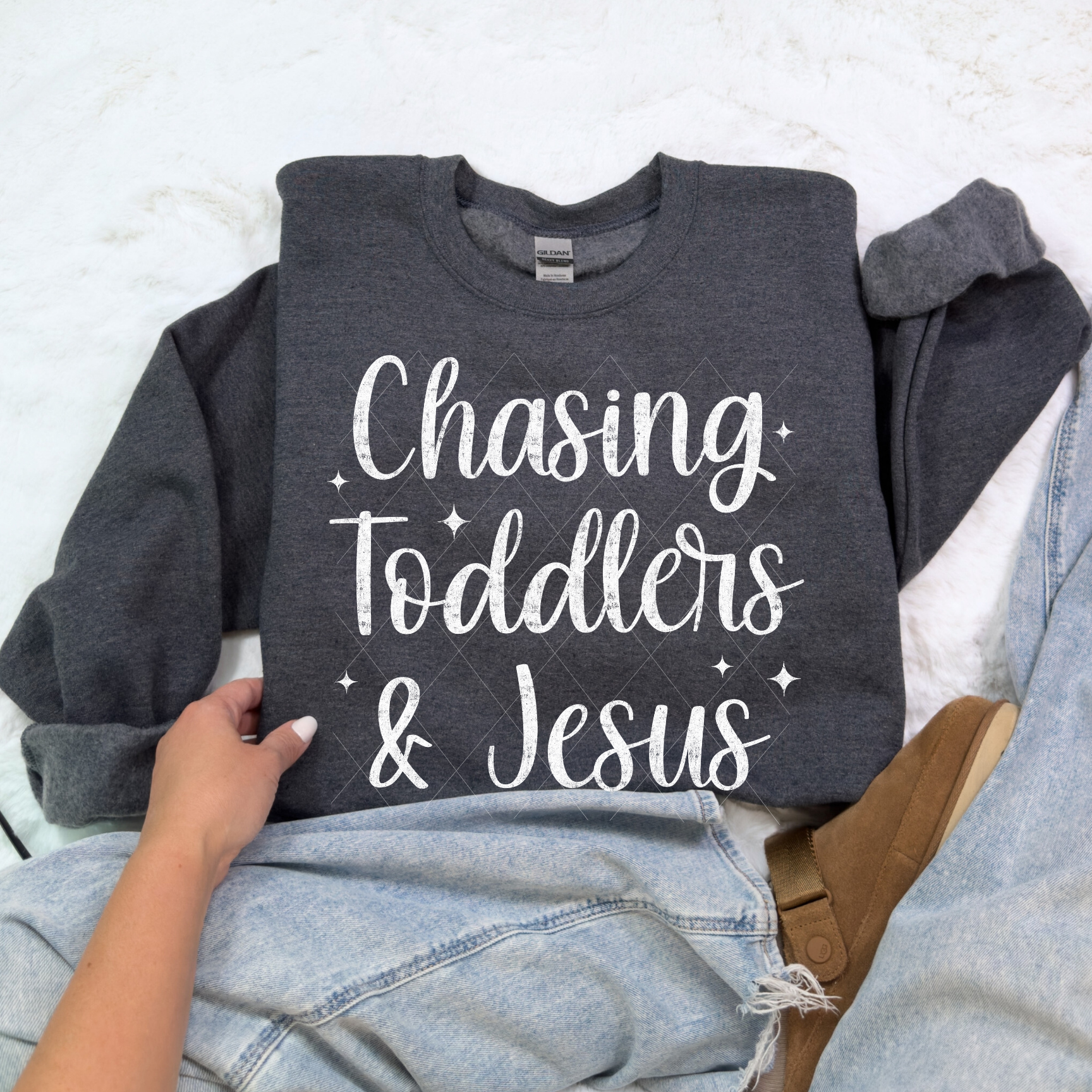Chasing Toddlers & Jesus sweatshirt in Dark Heather — cozy mom life sweatshirt paired with denim and slippers.