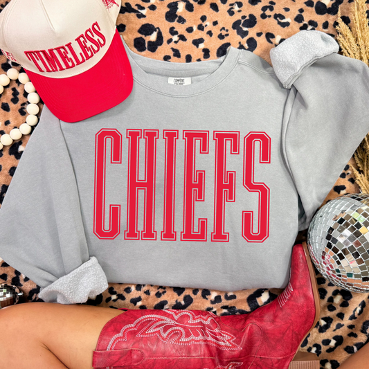 Gray Comfort Colors sweatshirt with 'CHIEFS' in red text, red cap, and red boots on a leopard print background.