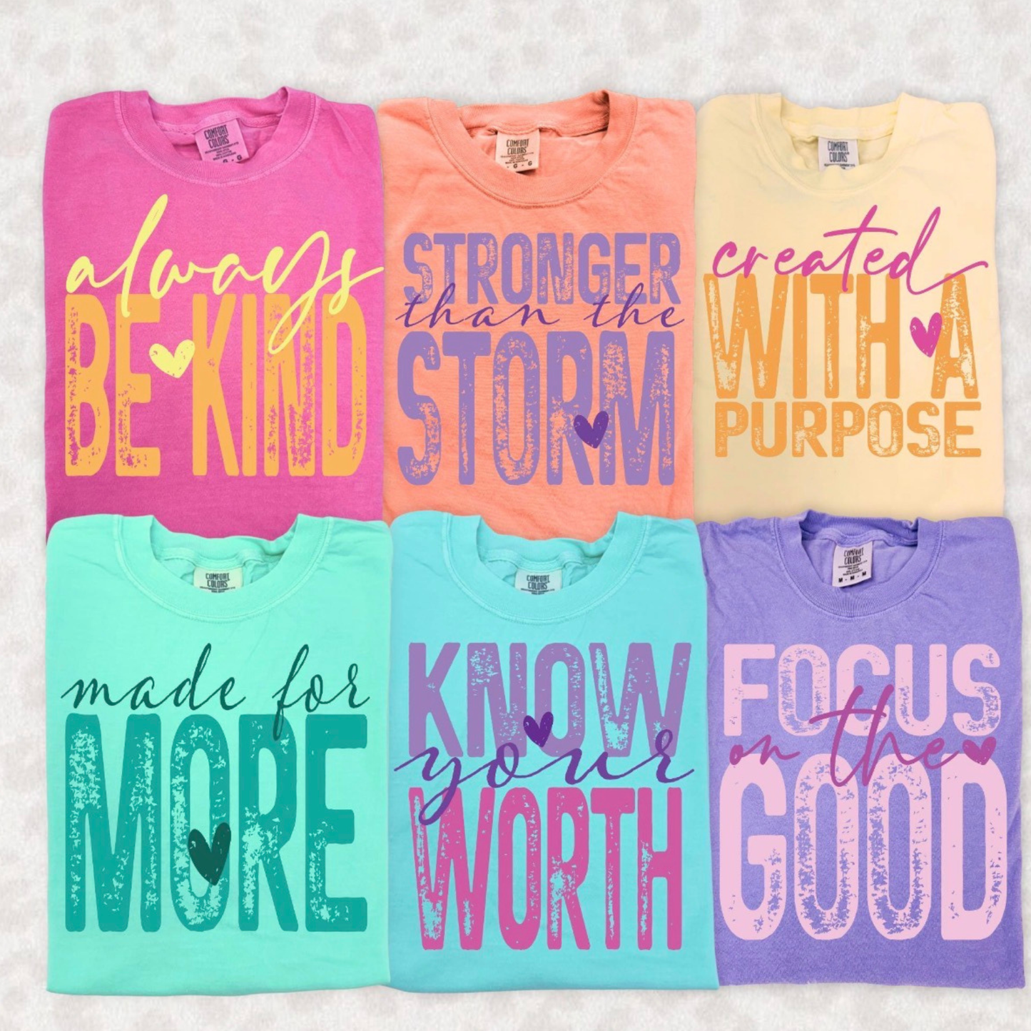 Colorful Comfort Colors inspirational graphic t-shirts featuring uplifting sayings including Always Be Kind, Stronger Than The Storm, Created With A Purpose, Made For More, Know Your Worth, and Focus On The Good.