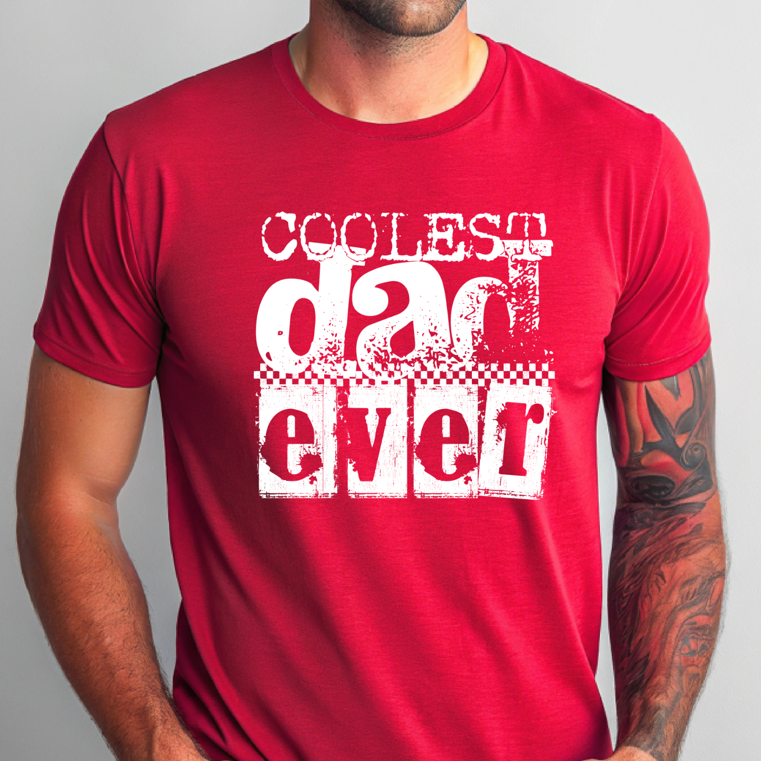 Coolest Dad Ever vintage graphic shirt featuring distressed retro typography and checkerboard accents on red shirt.