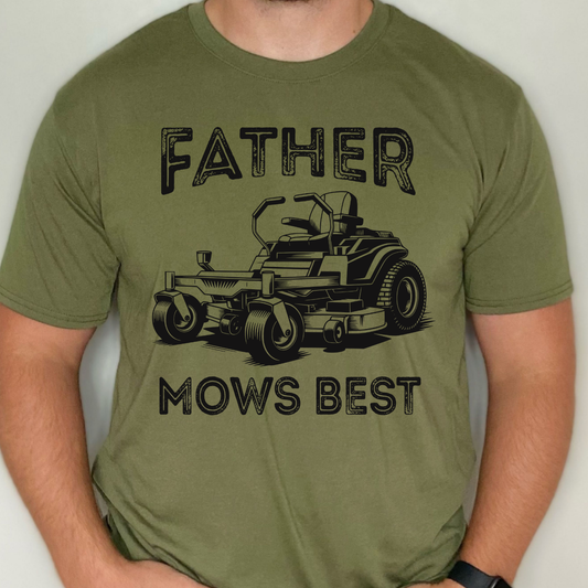 Father Mows Best graphic t-shirt featuring a riding lawn mower illustration and distressed typography on a military green shirt.