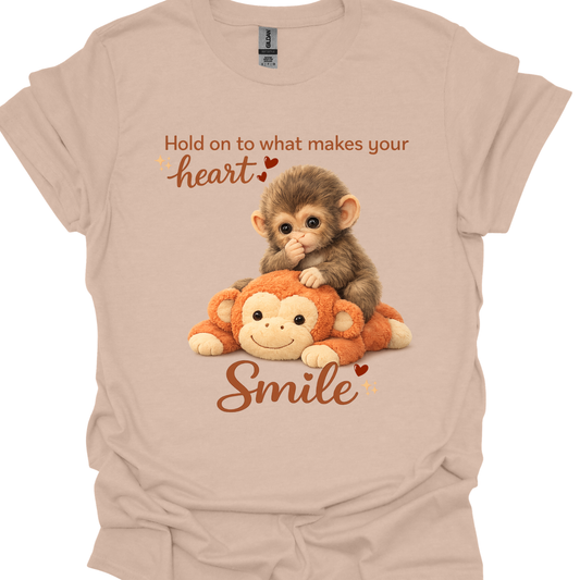 Adult t-shirt with punch the baby monkey lying on an orange plush monkey and the quote ‘Do what makes your heart smile’ in warm lettering.