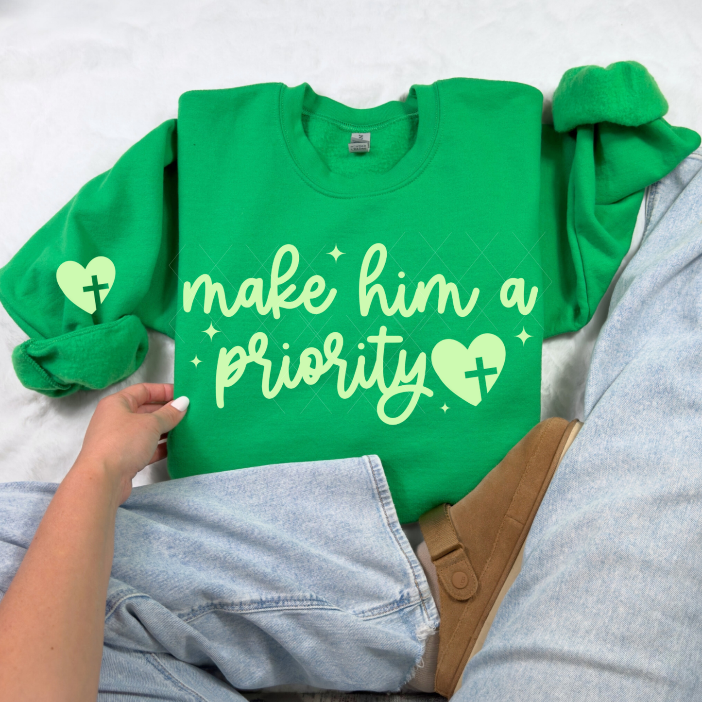 Irish green Make Him a Priority sweatshirt with light script lettering and heart-cross accent, styled on white backdrop.