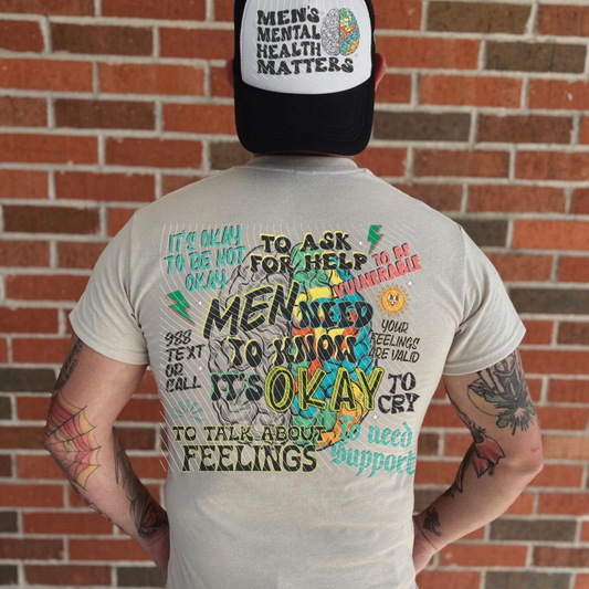 Back of a black and white men's graphic t-shirt featuring supportive men's mental health affirmations surrounding a colorful brain illustration with a matching front pocket design promoting mental health awareness.