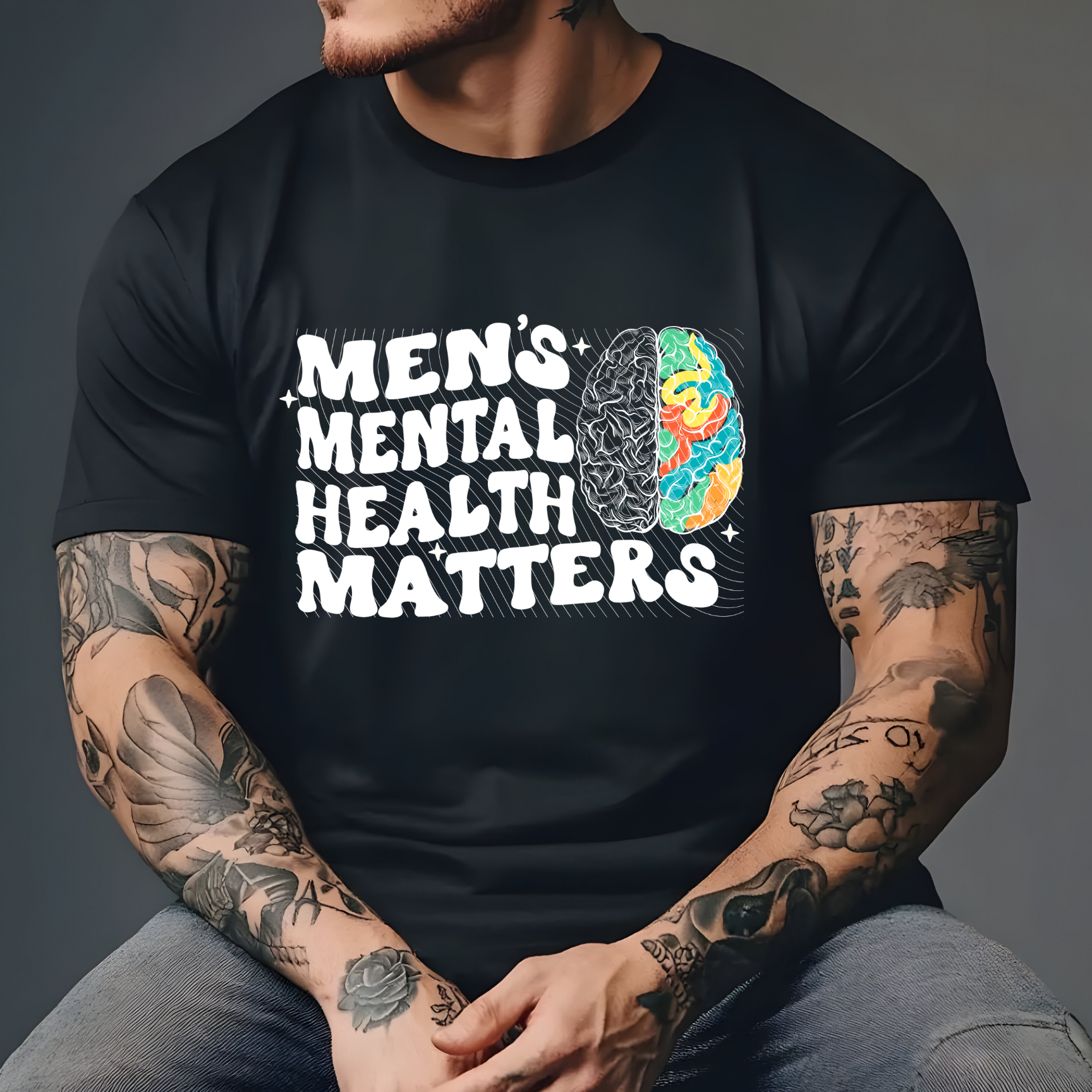 Man wearing a Men's Mental Health Matters graphic t-shirt featuring bold typography and a colorful brain illustration promoting mental health awareness and suicide prevention.