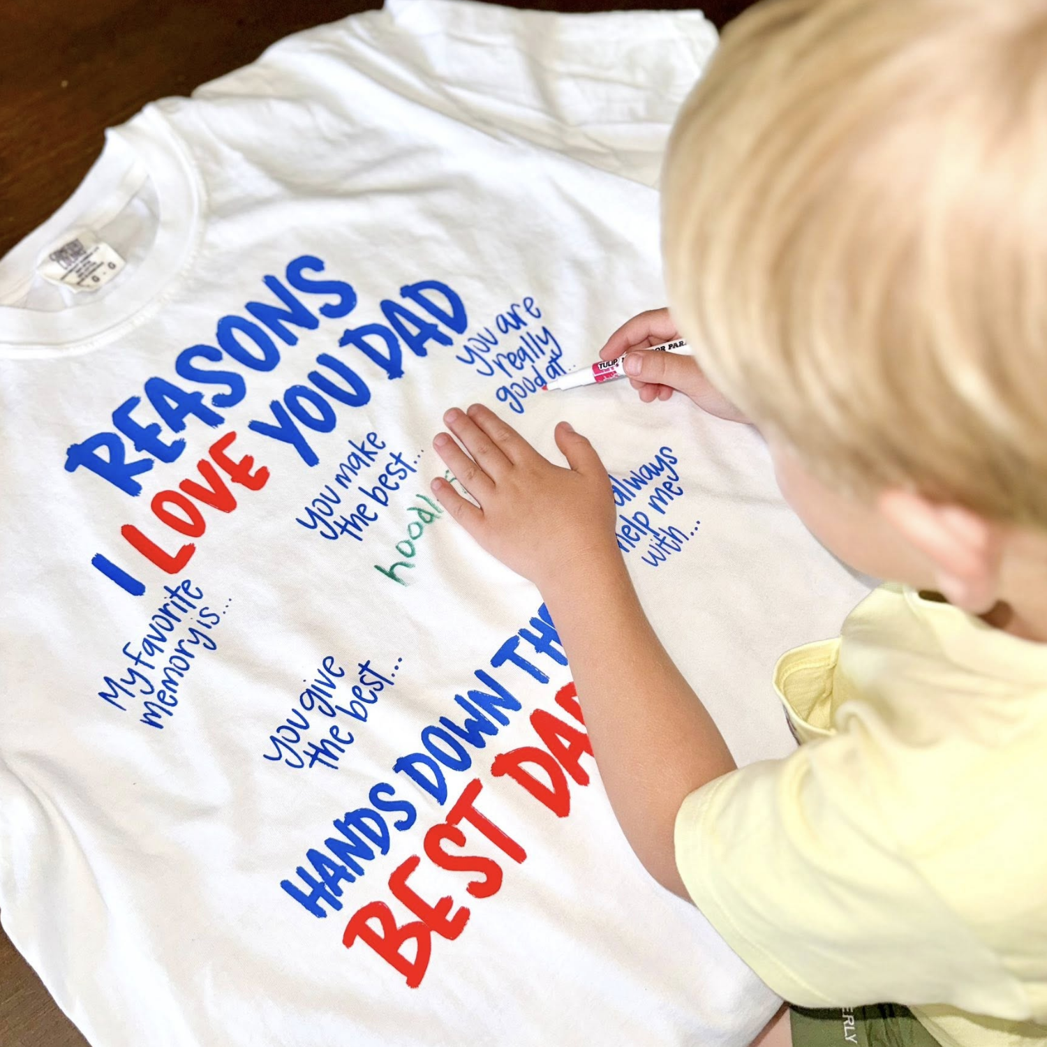 Personalized Reasons I Love You Dad shirt featuring a child's handwritten answers, memories, drawings, and messages printed on a custom Father's Day keepsake shirt. 