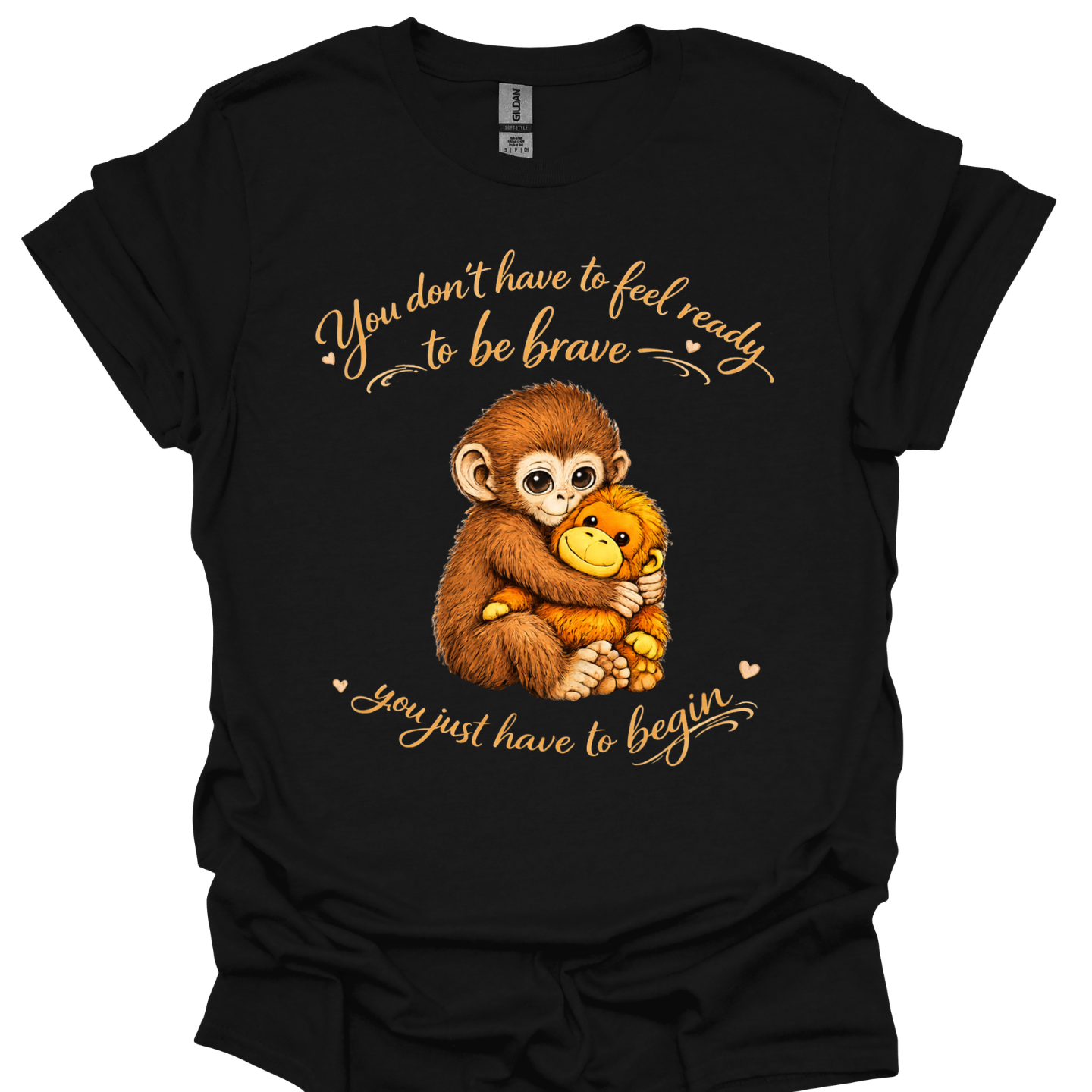 Kids t-shirt with punch the baby monkey hugging a plush toy and the quote ‘You don’t have to feel ready to be brave, you just have to begin’ in warm lettering.