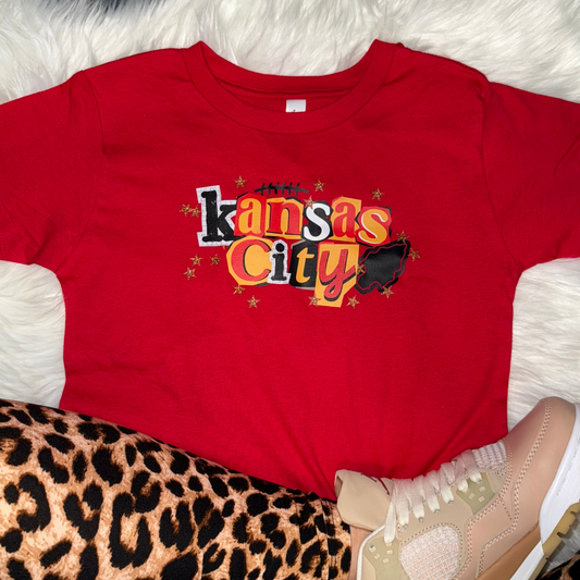 Red t-shirt with 'Kansas City' print on a textured surface