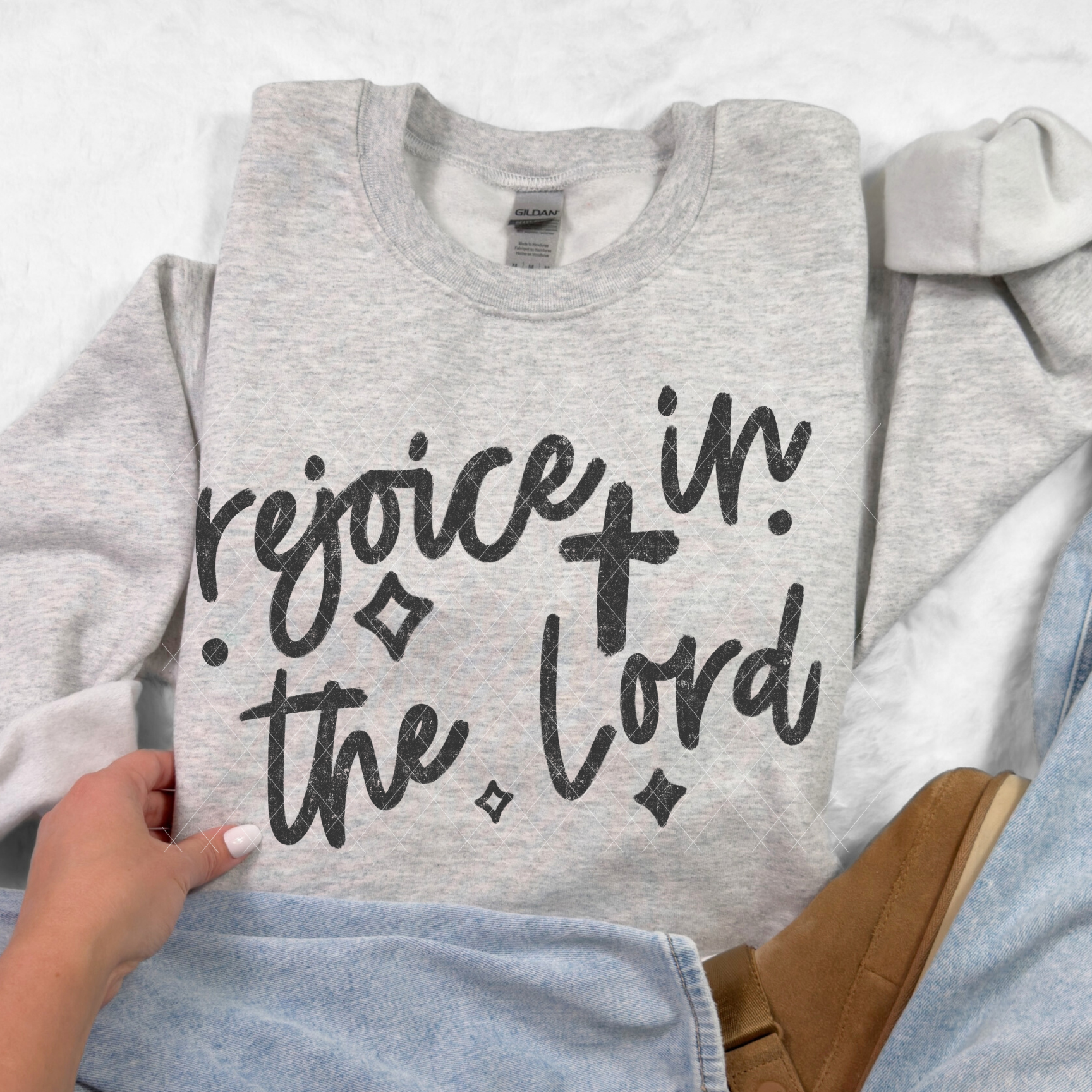 Ash gray Gildan crewneck featuring black ‘Rejoice in the Lord’ script design paired with cozy casual outfit.